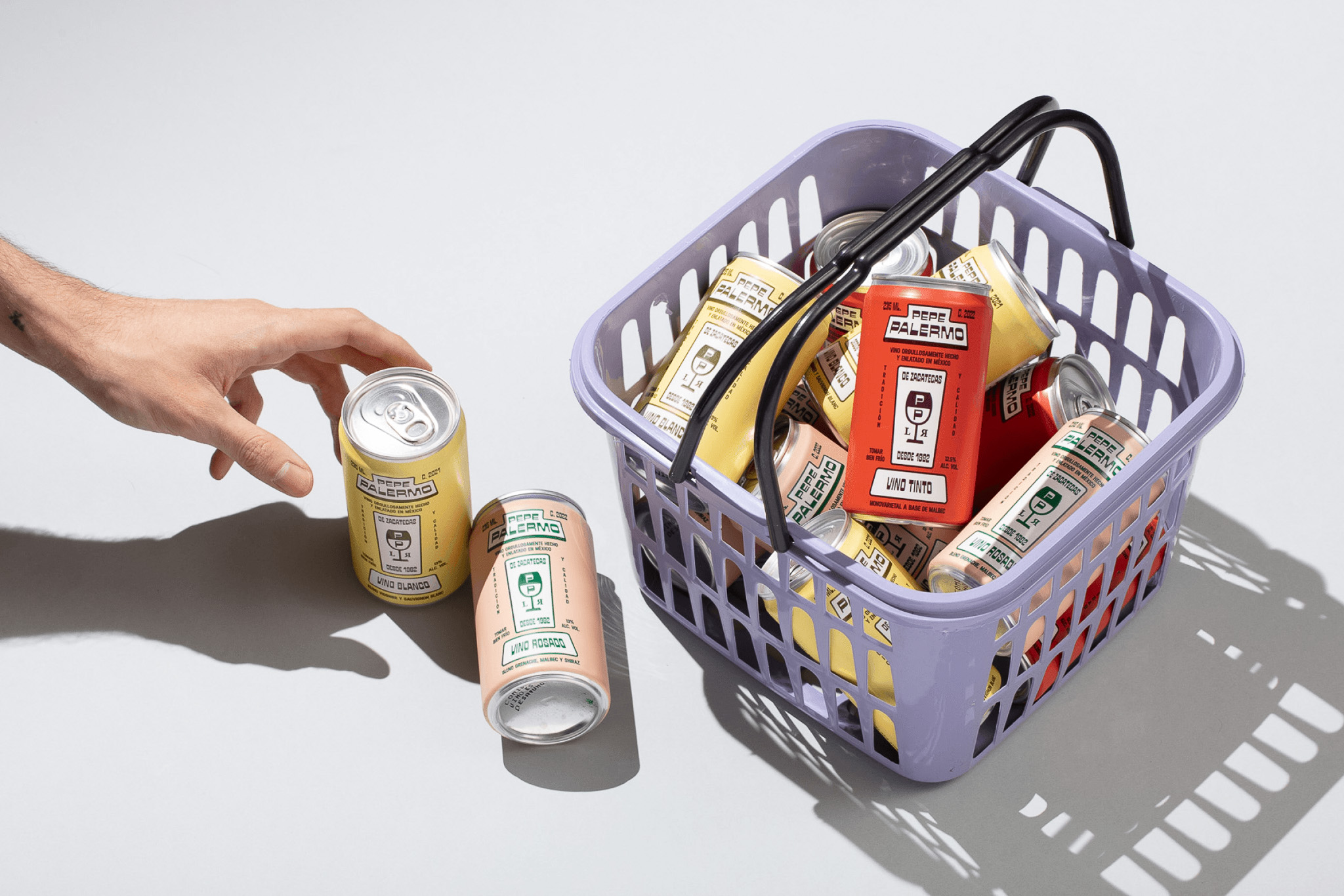 Basket with assorted Pepe Palermo canned wines in red, yellow, and pink tones.