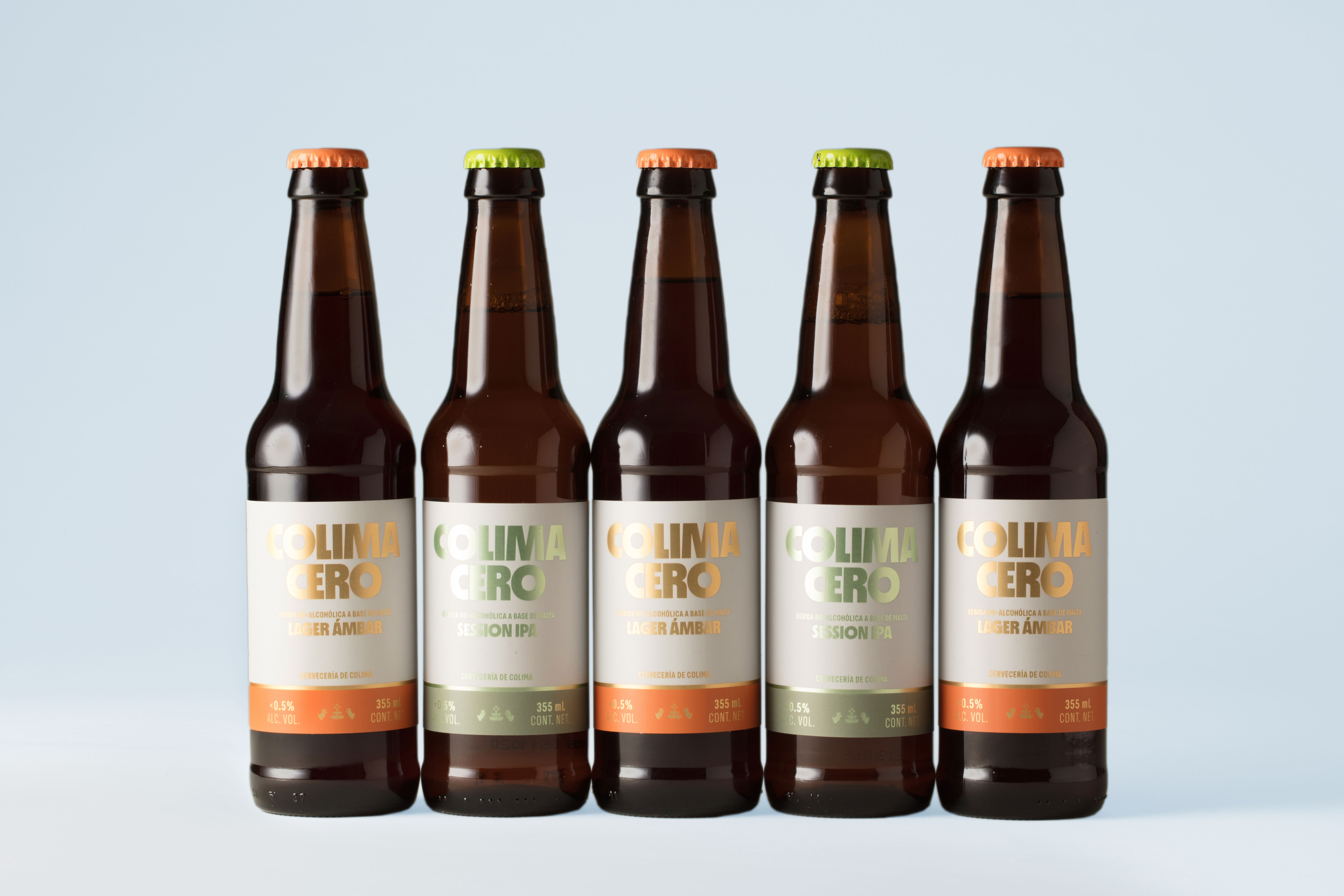 Colima Cero bottles aligned horizontally with metallic labels in gold and green.